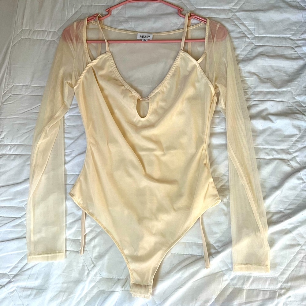 Mesh long-sleeve bodysuit with halter tie & keyhole opening.